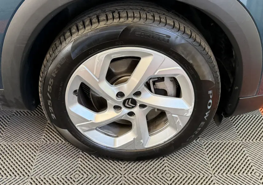 Gros plan sur la roue avant droite du Citroën C5 Aircross Hybrid bleu, mettant en valeur la jante alliage et le pneu Pirelli.