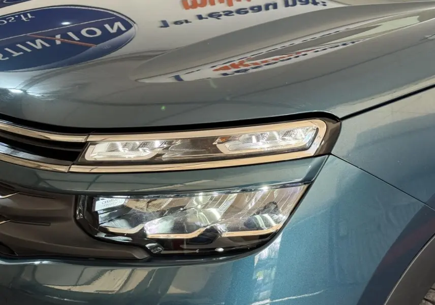 Gros plan sur le phare avant droit du Citroën C5 Aircross Hybrid 225 bleu, mettant en valeur son design LED distinctif.