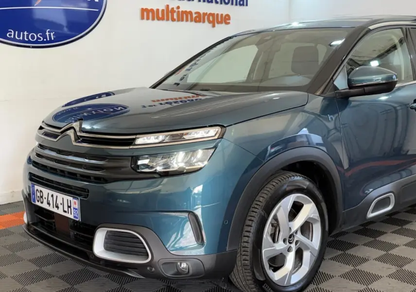 Vue 3/4 avant droit d'un Citroën C5 Aircross Hybrid bleu avec phares LED et jantes alliage distinctives.