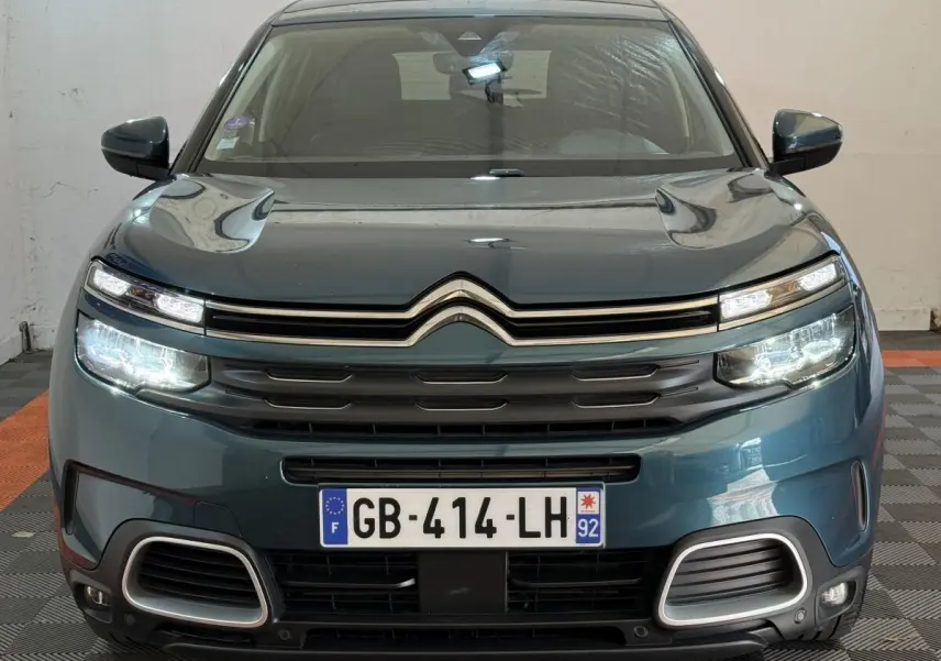 Vue frontale d'un Citroën C5 Aircross Hybrid bleu avec phares LED allumés et calandre distinctive.