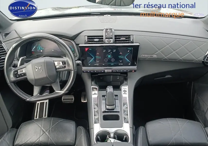 Vue intérieure avant du DS7 Crossback E-tense 4x4 300 rivoli, tableau de bord et volant cuir noir avec coutures croisées.