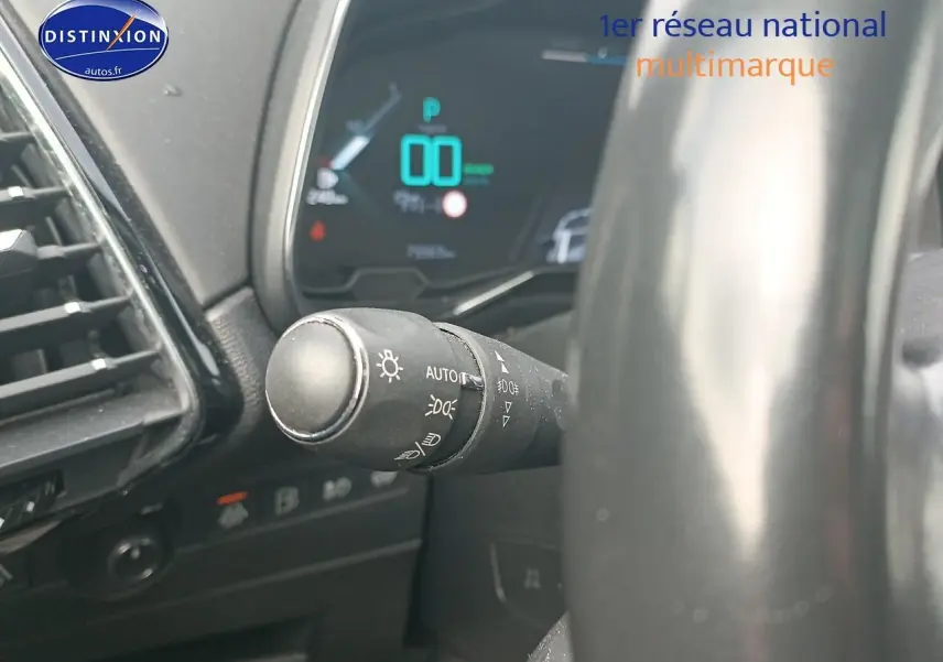 Gros plan sur la commande des phares à gauche du volant dans l’habitacle du DS7 Crossback E-tense gris platinium.