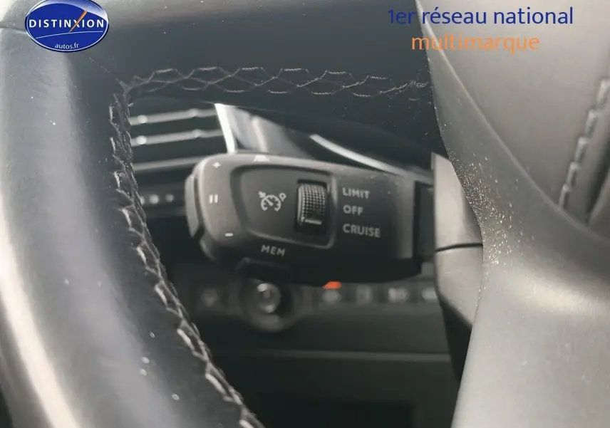 Gros plan sur la commande de régulateur de vitesse derrière le volant cuir du DS7 Crossback gris platinium.