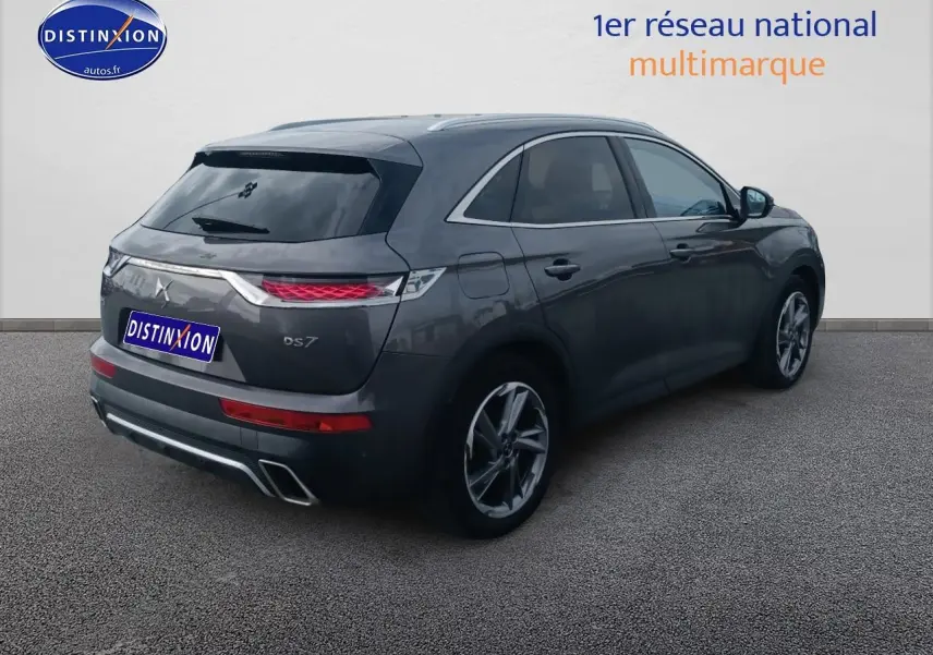 Vue 3/4 arrière droit du DS7 Crossback E-tense gris platinium avec feux arrière LED et double sortie d’échappement.