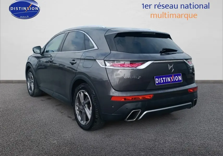 Vue 3/4 arrière droite d'un DS7 Crossback E-tense gris platinium avec feux LED et double sortie d'échappement.
