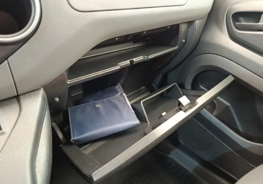 Vue intérieure côté passager du Peugeot Partner 1.6 BlueHDi 2018, boîte manuelle, boîte à gants ouverte avec pochette bleue.