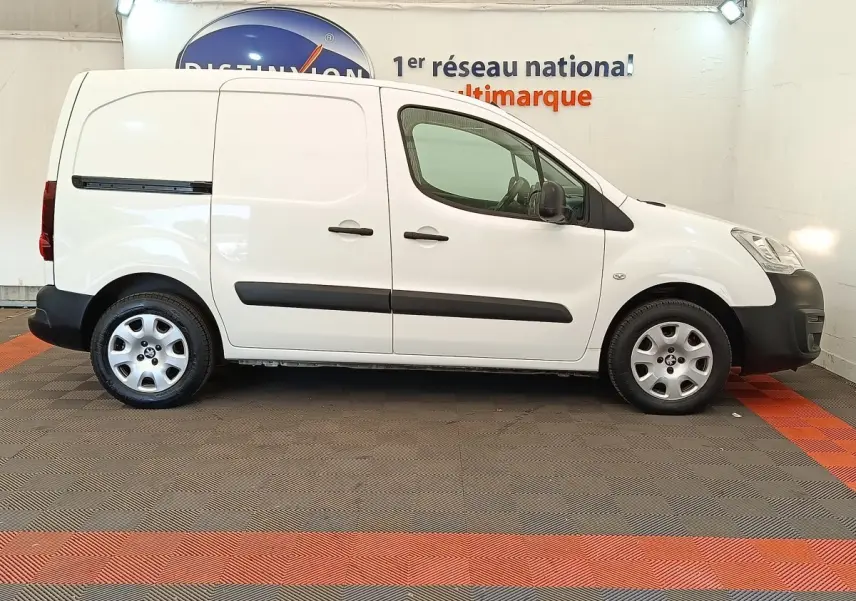 Vue latérale droite d'un utilitaire Peugeot Partner blanc 2018 avec protections noires et jantes acier.