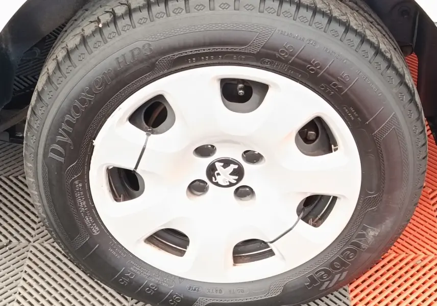Gros plan sur la roue avant droite blanche d’un Peugeot Partner 1.6 BlueHDi 100 Long Pro de 2018.