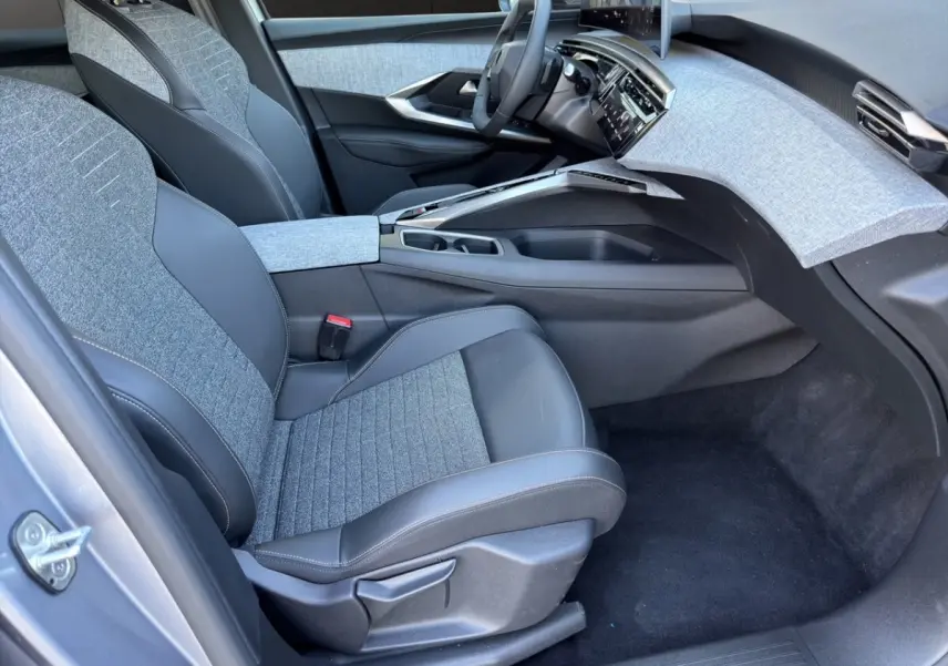 Intérieur avant droit du Peugeot 3008 gris clair 2025, sièges tissu et cuir, tableau de bord avec écran tactile.