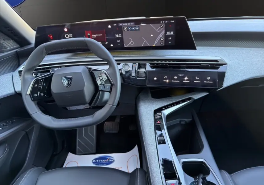 Vue intérieure du tableau de bord et volant cuir du Peugeot 3008 1.2 Hybrid gris clair, avec écran tactile panoramique.