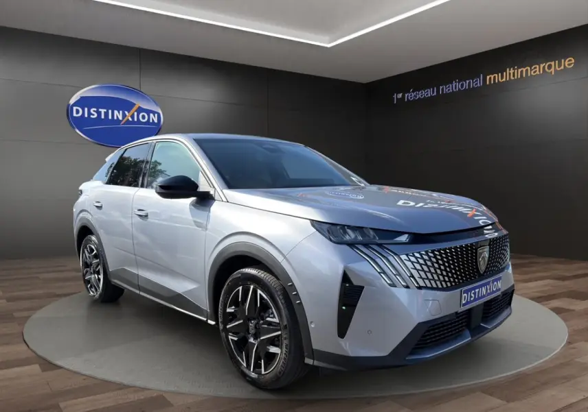 Peugeot 3008 gris clair en 3/4 avant droit, avec calandre distinctive et jantes noires en showroom.