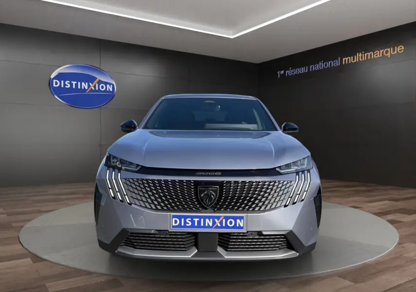 Vue avant du Peugeot 3008 gris clair 2025 avec calandre distinctive et feux LED verticaux en showroom Distinxion.