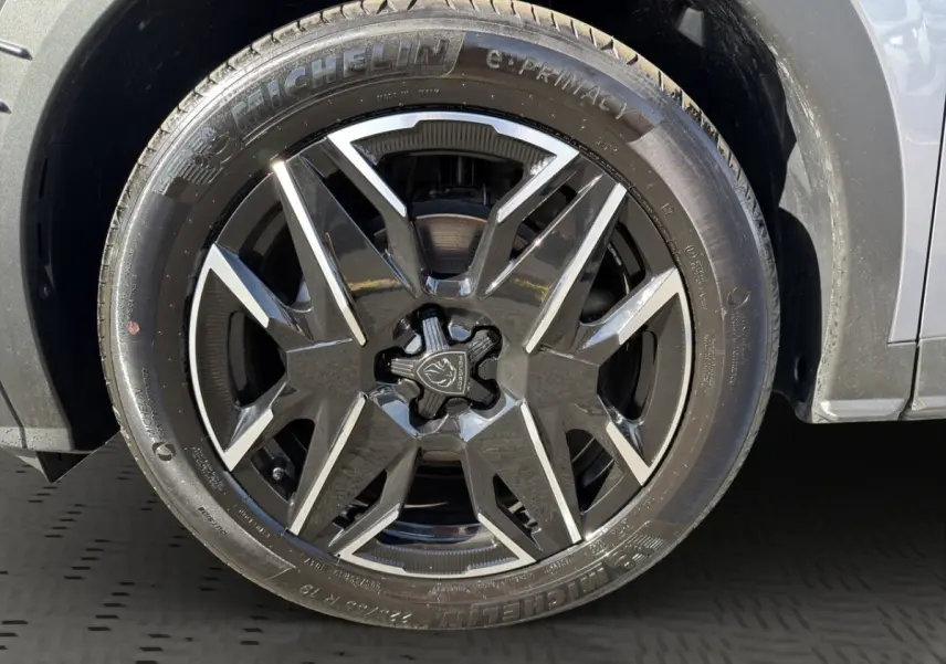 Gros plan sur la roue avant droite du Peugeot 3008 gris clair, jante alliage noire et argentée au design moderne.