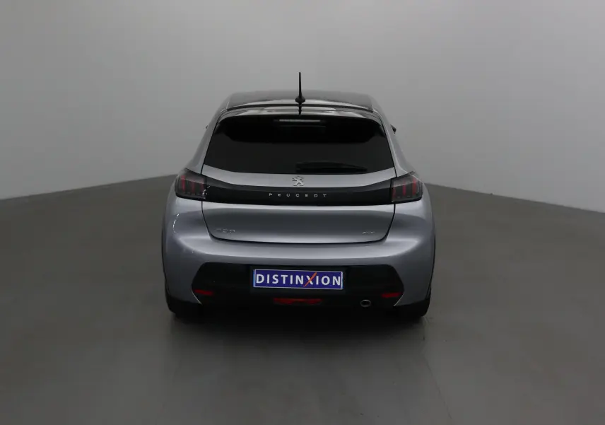 Vue arrière d'une Peugeot 208 GT 2023 en gris Artense avec vitre arrière teintée et logo distinctif Peugeot.