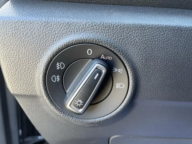 Gros plan sur le sélecteur d'éclairage noir du Volkswagen T-Roc 1.5 TSI 150 gris foncé métal de 2021, avec mode automatique.