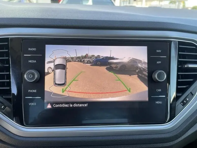 Vue de la caméra de recul du Volkswagen T-Roc gris foncé métal 2021, avec guidage de trajectoire affiché à l'écran.