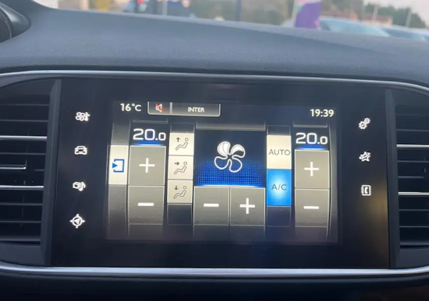 Écran tactile multifonction de la Peugeot 308 blanc, affichant les réglages de climatisation automatique bi-zone.