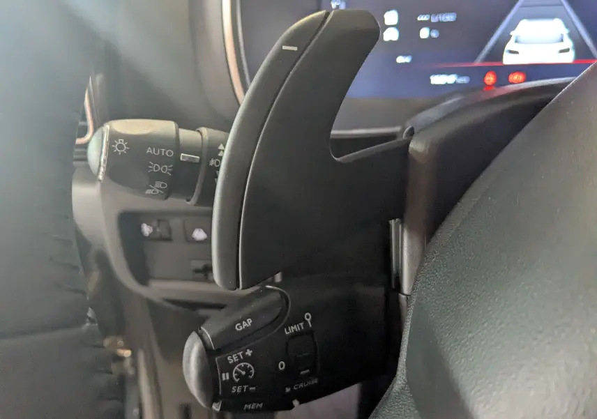 Détail du volant et commandes de régulateur de vitesse du Citroën C5 Aircross hybride gris platinium 2024.