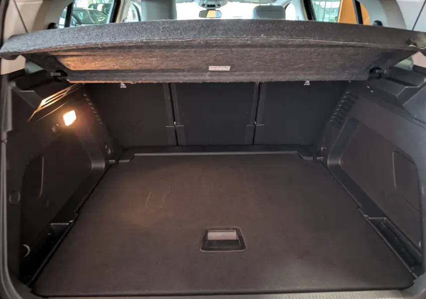 Coffre ouvert du Citroën C5 Aircross hybride gris platinium, vue intérieure arrière montrant l'espace de chargement vide.