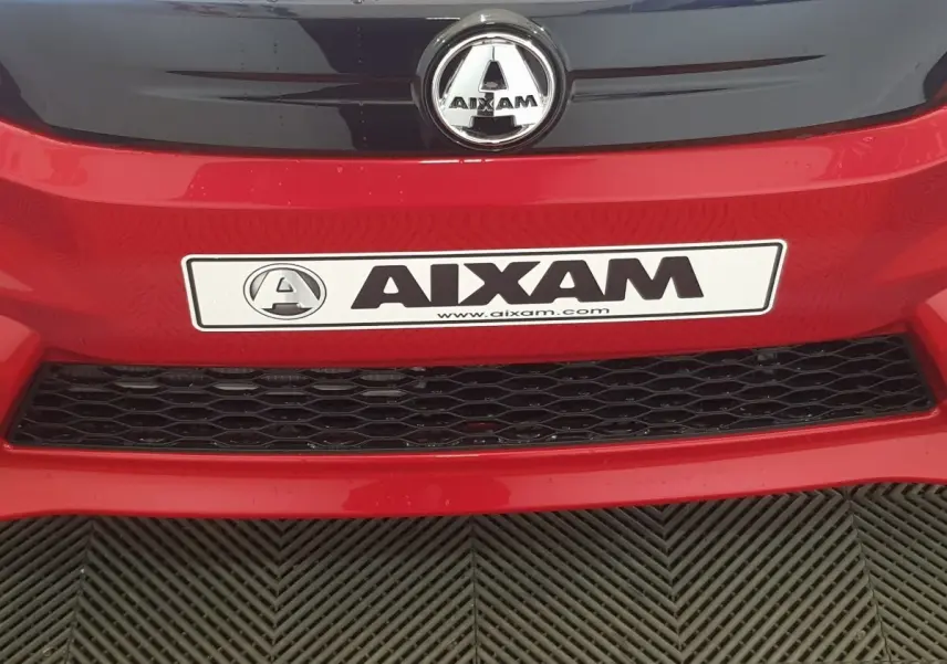 Gros plan sur la face avant rouge de l'AIXAM Ambition 0.5 City Pack avec logo et plaque visible.