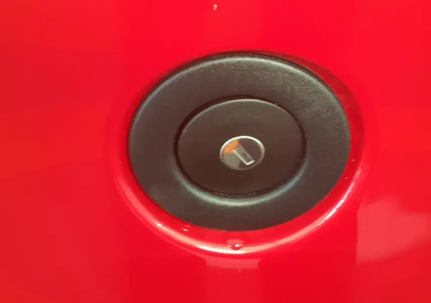 Détail du bouchon de réservoir noir sur la carrosserie rouge vif de l'AIXAM AMBITION 0.5 CITY PACK 2026.