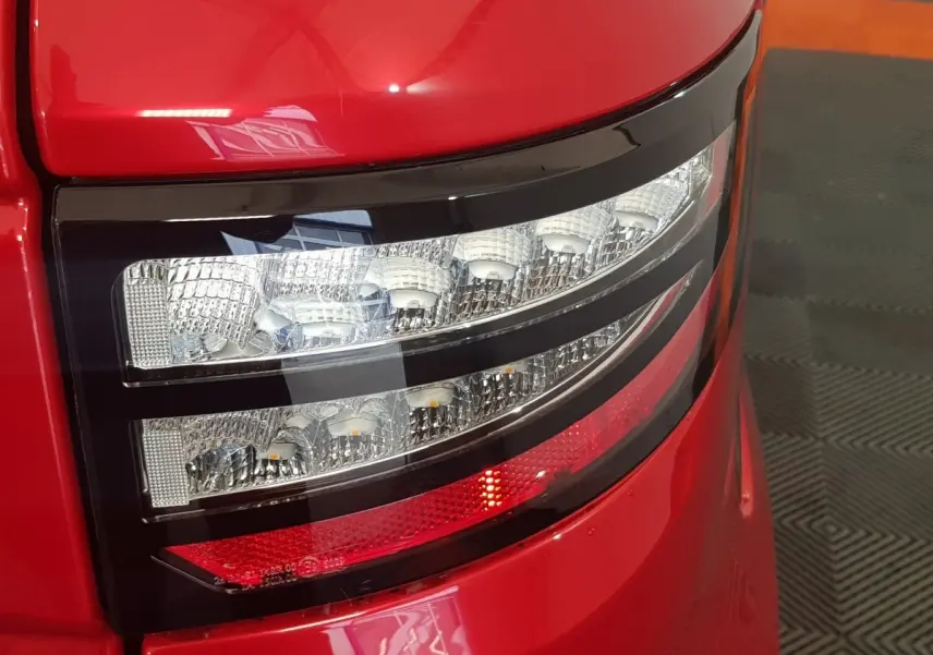 Gros plan sur le feu arrière droit rouge et blanc de l'AIXAM AMBITION 0.5 CITY PACK rouge 2026.