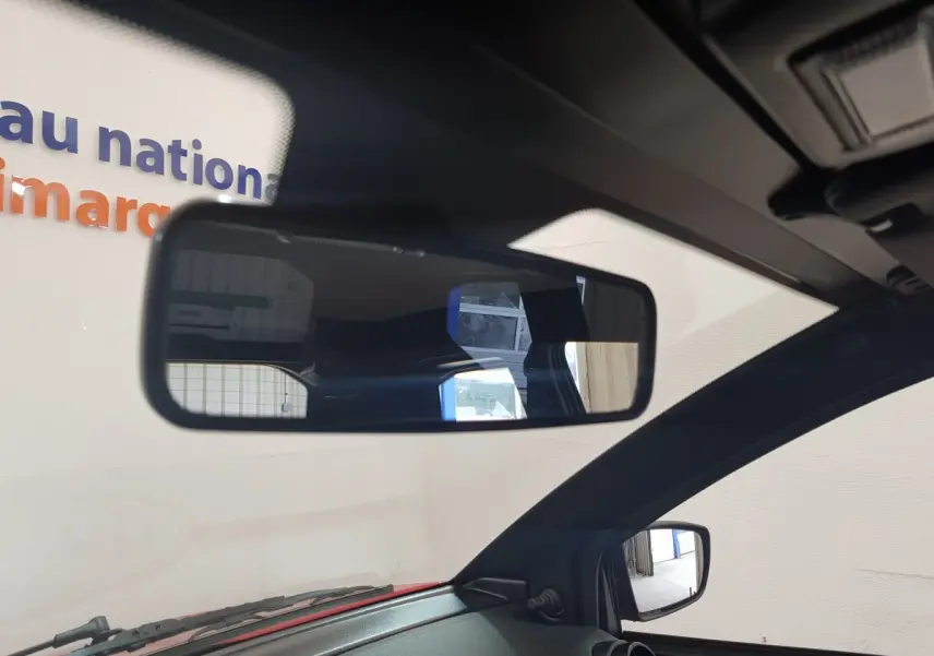 Vue intérieure centrée sur le rétroviseur intérieur et le rétroviseur caméra côté gauche d'une Aixam Ambition rouge 2026.