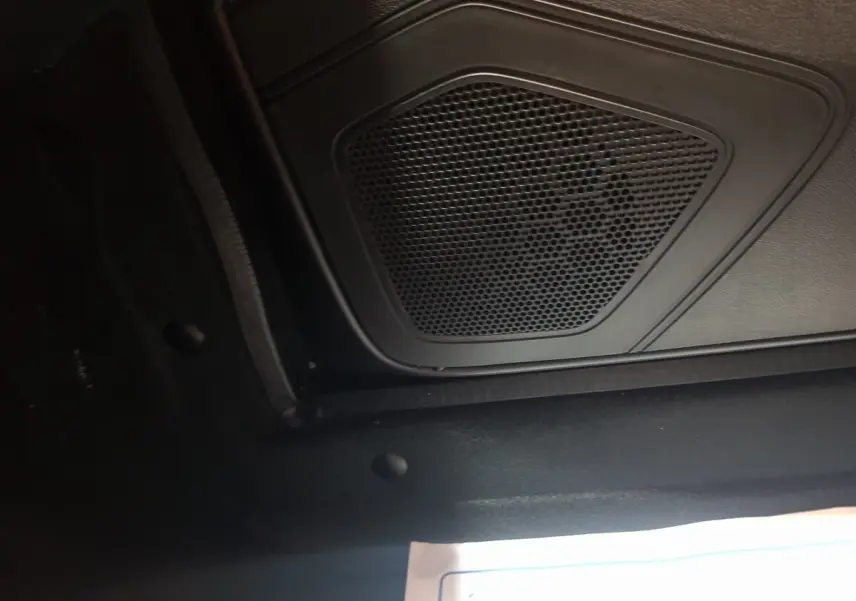 Gros plan sur le haut-parleur intérieur noir de l'AIXAM AMBITION 0.5 CITY PACK, sans vue extérieure ni couleur rouge visible.