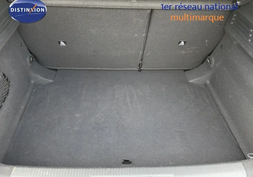 Coffre spacieux de la Peugeot 308 noir métal, vue intérieure montrant le revêtement et les rangements latéraux.