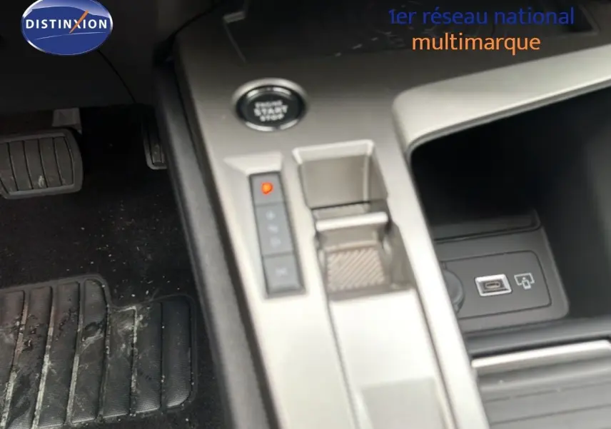 Gros plan sur la console centrale de la Peugeot 308 1.2 Hybrid 145ch Allure, avec bouton start/stop et prise USB visible.