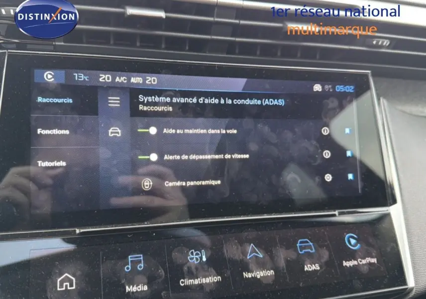 Écran tactile intérieur de la Peugeot 308 noir métal, affichant les aides à la conduite et la climatisation.