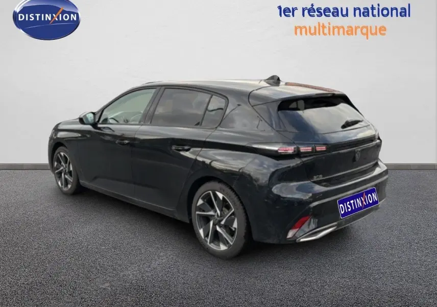 Vue 3/4 arrière droite d'une Peugeot 308 noire métal 2025 avec feux arrière LED et jantes alliage bicolores.