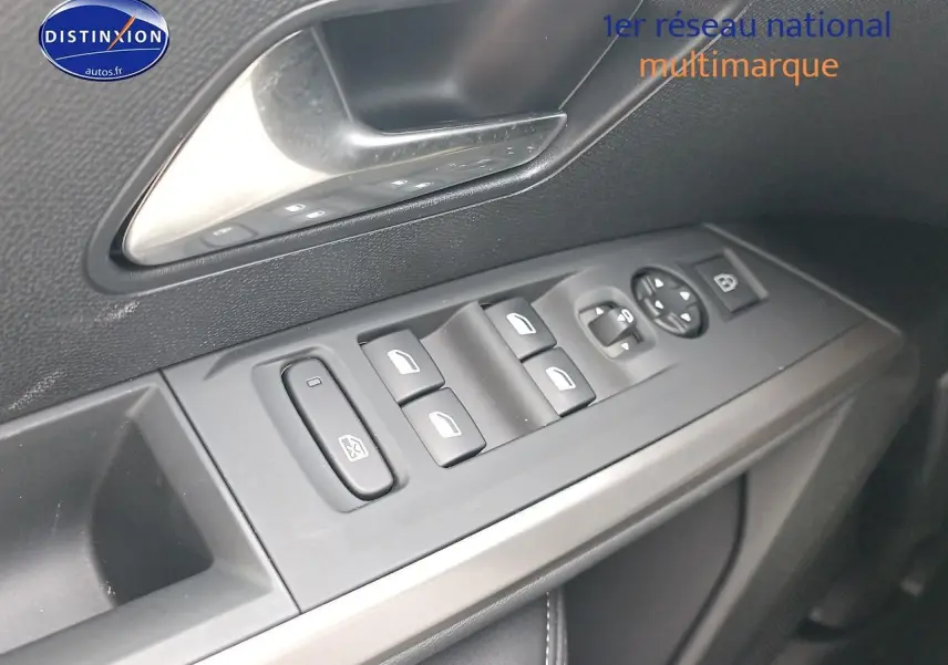 Vue rapprochée des commandes des vitres et rétroviseurs sur la porte avant gauche d’un Peugeot 3008 bleu 2025.