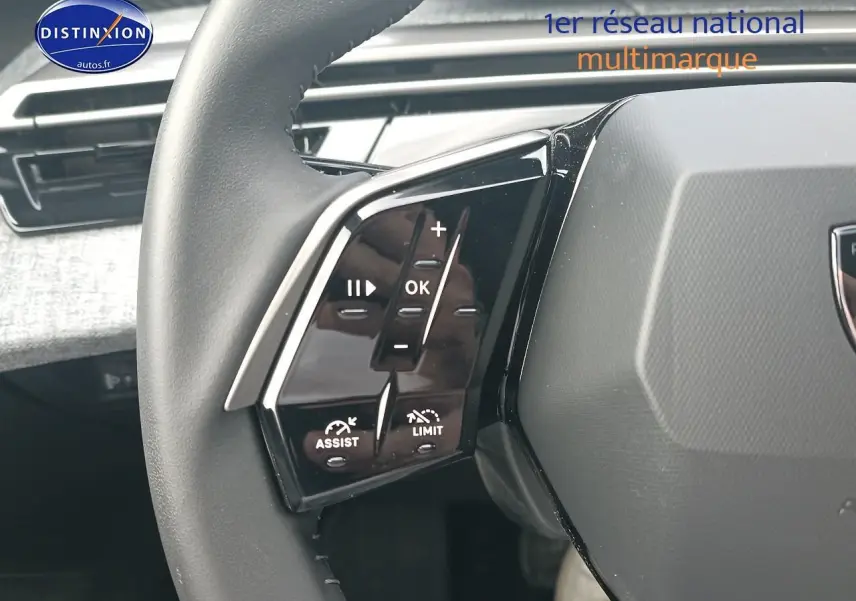 Gros plan sur les commandes multifonctions côté gauche du volant cuir de la Peugeot 3008 bleu 2025.