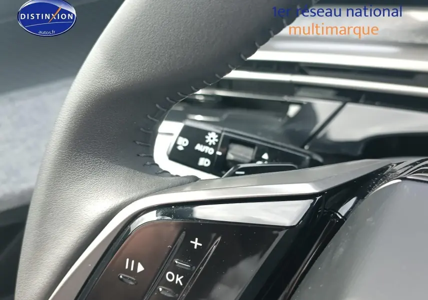 Gros plan sur le volant cuir multifonction côté gauche du Peugeot 3008 bleu, avec commandes audio visibles.