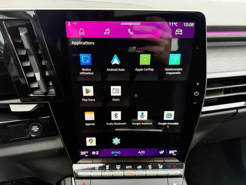 Écran tactile central du tableau de bord du Renault Austral 2025, affichant les applications connectées, avec commandes climatisation en dessous.