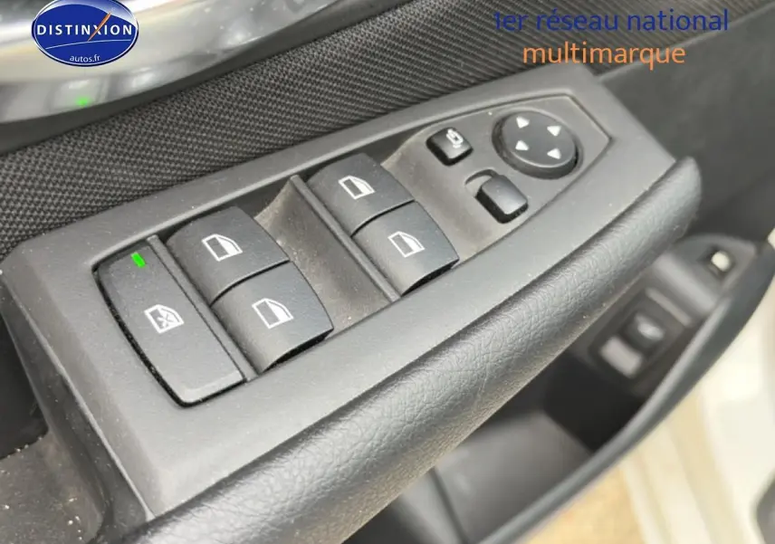 Gros plan sur les commandes des vitres et rétroviseurs côté gauche d'une BMW Série 2 Active Tourer gris argent.
