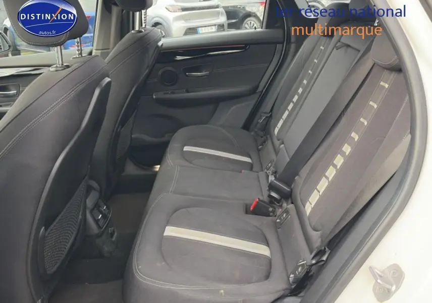Vue intérieure côté droit montrant la banquette arrière en tissu anthracite avec bandes claires d'une BMW Série 2 Active Tourer gris argent.
