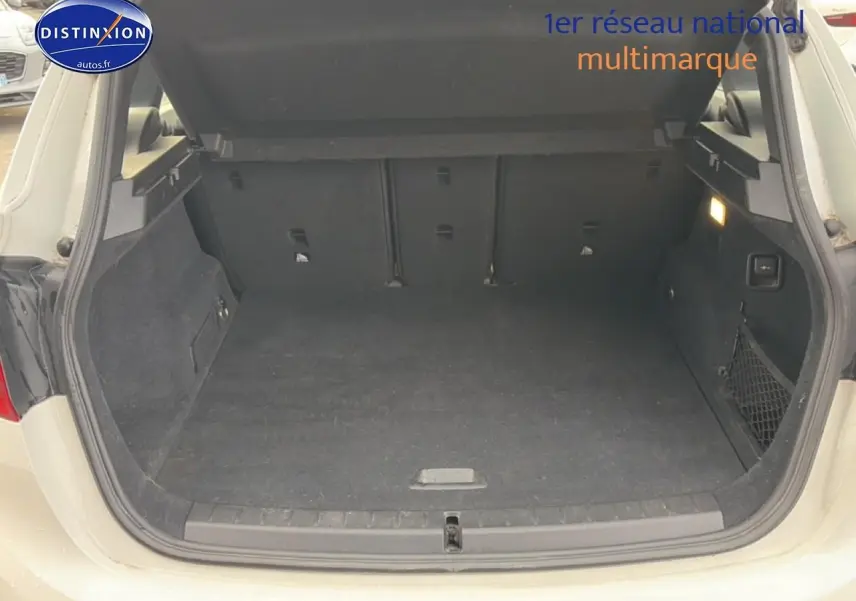 Coffre ouvert vu de l'arrière d'une BMW Série 2 Active Tourer gris argent, espace de chargement spacieux et propre.