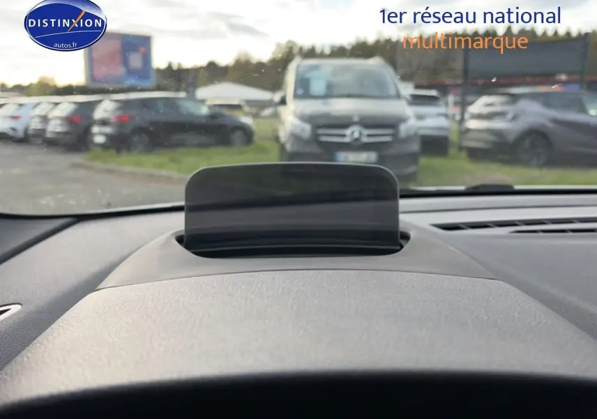 Affichage tête haute déployé sur le tableau de bord gris d'une BMW Série 2 Active Tourer, vue depuis le siège conducteur.