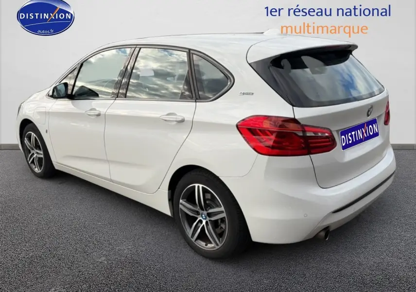 Vue 3/4 arrière droite d'une BMW Série 2 Active Tourer gris argent avec jantes alliage et becquet arrière noir.