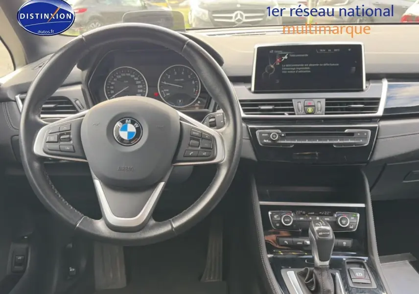 Vue intérieure centrée sur le volant cuir multifonction et la console centrale d'une BMW Série 2 Active Tourer gris argent.