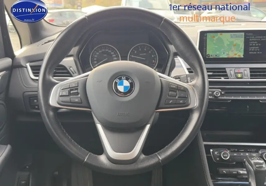 Vue centrée sur le volant cuir multifonction noir de la BMW Série 2 Active Tourer avec tableau de bord et écran GPS.