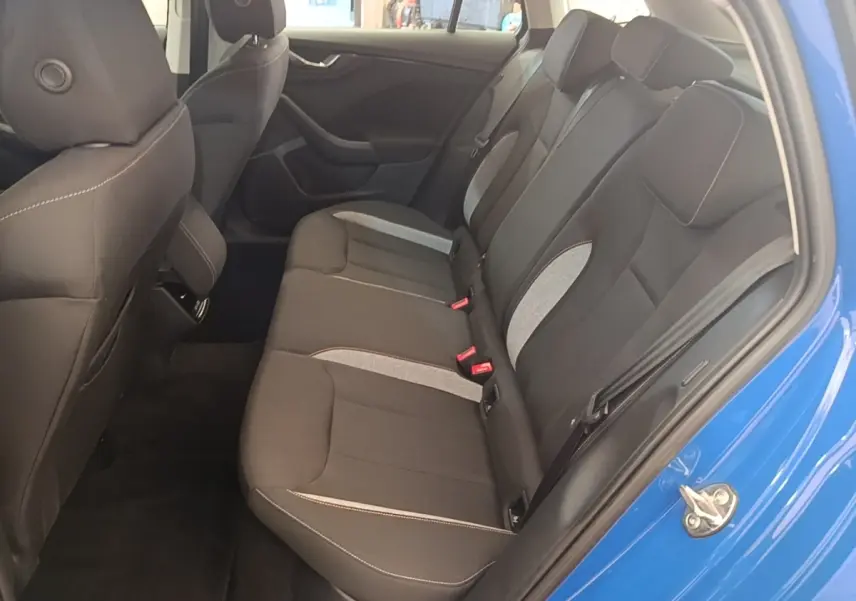 Vue intérieure côté droit des sièges arrière noirs avec inserts gris d'une Skoda Scala bleu 2024.