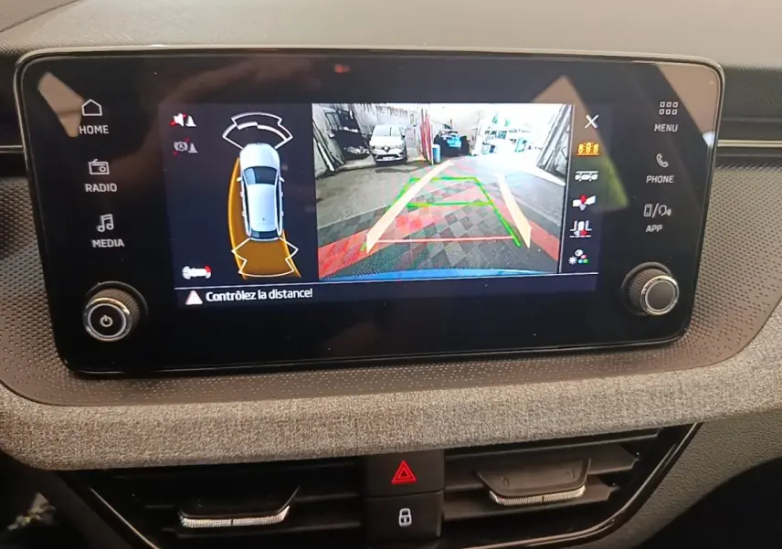 Écran tactile central montrant la caméra de recul et l’aide au stationnement du Skoda Scala 2024.