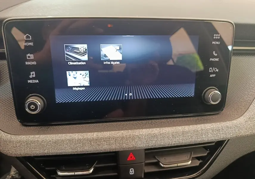 Écran tactile central du tableau de bord de la Skoda Scala 2024 avec commandes climatisation et médias visibles.
