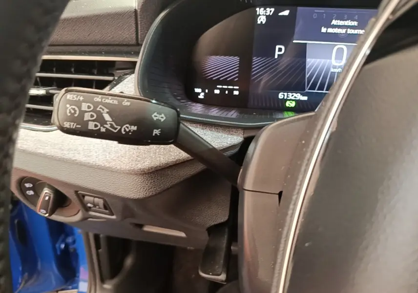 Vue rapprochée du tableau de bord et du volant du Skoda Scala bleu, avec affichage digital et commandes au volant visibles.