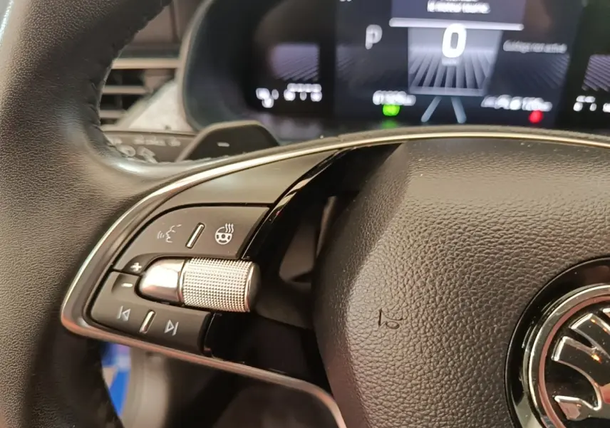 Gros plan sur le volant cuir et alu multifonctions côté gauche du Skoda Scala 2024, avec tableau de bord numérique en arrière-plan.