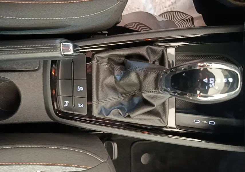 Vue plongeante sur la console centrale de la Skoda Scala 1.5 TSI 2024, avec levier de vitesse DSG7 et frein à main cuir.