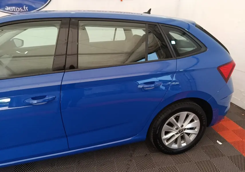 Vue côté droit arrière d'une SKODA SCALA bleu 2024 avec jantes alliage et vitres teintées.